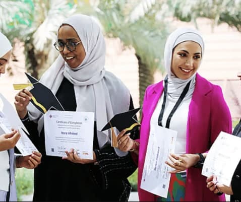 Graduates of the NOMU Al Ghurair Women in AI programme holding their certificates